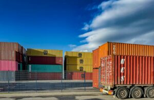 a truck is parked in front of a bunch of shipping containers